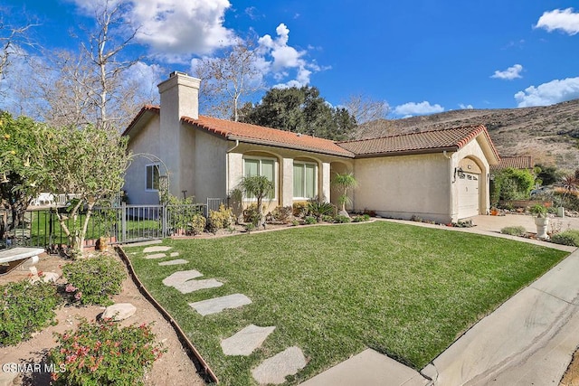 mediterranean / spanish house featuring a garage and a front lawn