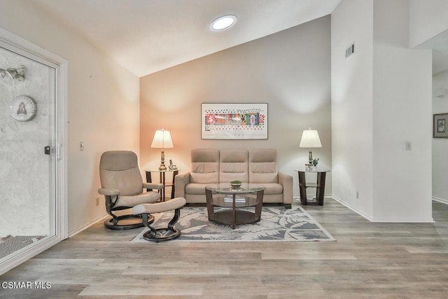 living room featuring vaulted ceiling and hardwood / wood-style flooring