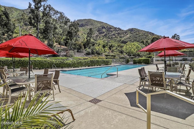 view of pool with a mountain view and a patio area