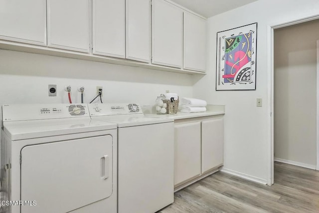 laundry room featuring independent washer and dryer, cabinets, and light wood-type flooring