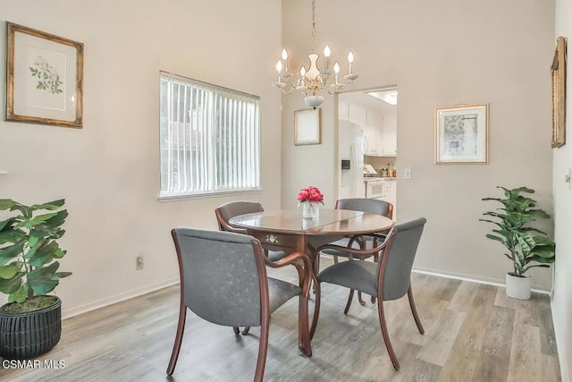 dining area featuring an inviting chandelier and light hardwood / wood-style flooring