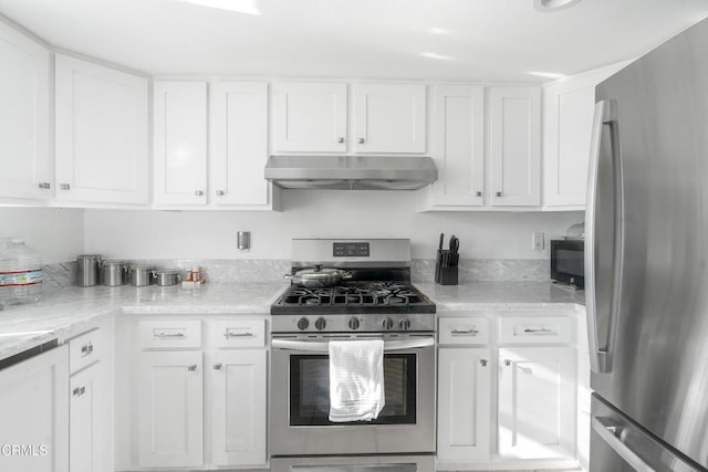 kitchen with light stone countertops, white cabinetry, and stainless steel appliances