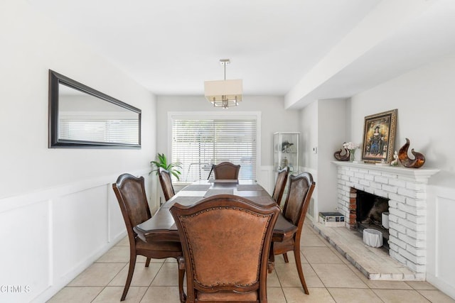 dining area featuring light tile patterned floors and a fireplace