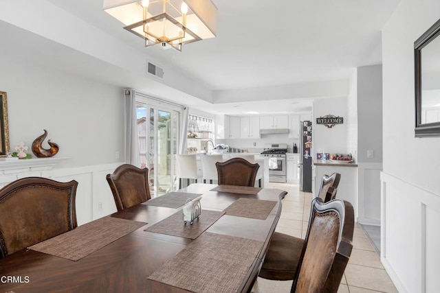 dining area featuring light tile patterned floors and a chandelier