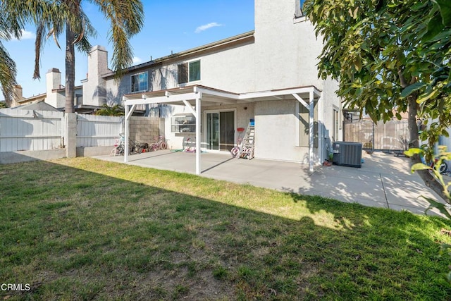 rear view of house featuring a patio, a lawn, and central air condition unit