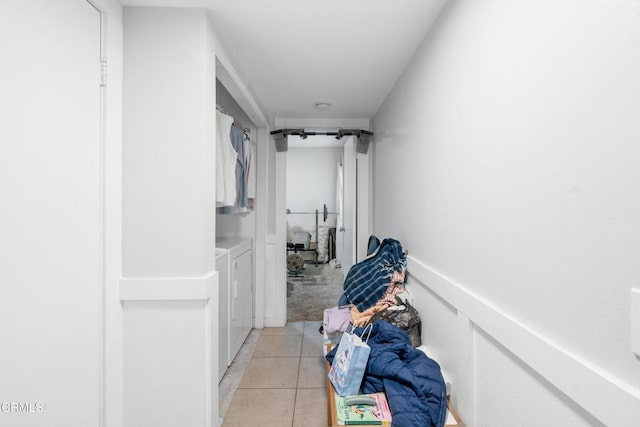 hall with washer and clothes dryer and light tile patterned floors