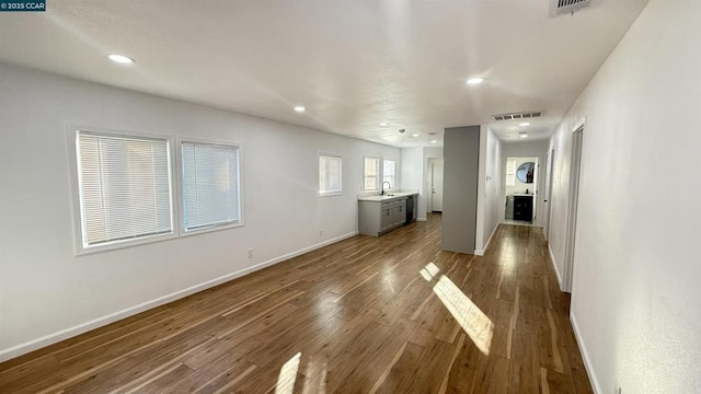 unfurnished living room with dark hardwood / wood-style floors and sink