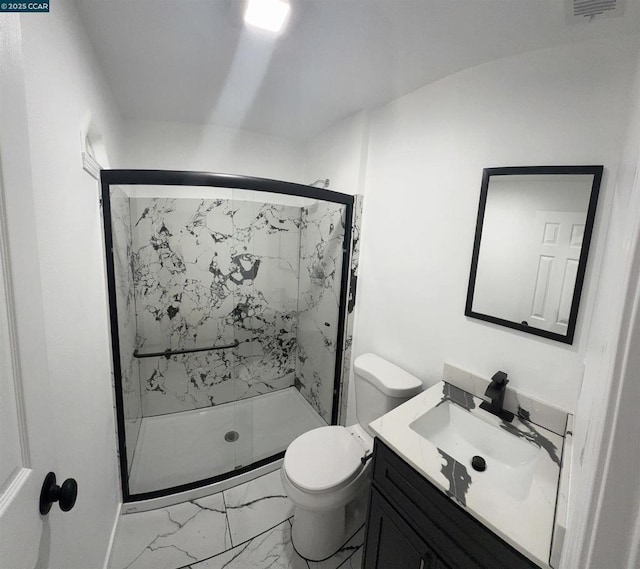 bathroom with a shower with shower door, vanity, and toilet