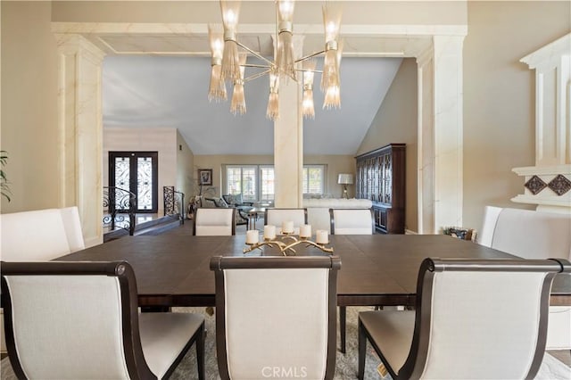 dining room featuring decorative columns, a chandelier, and vaulted ceiling