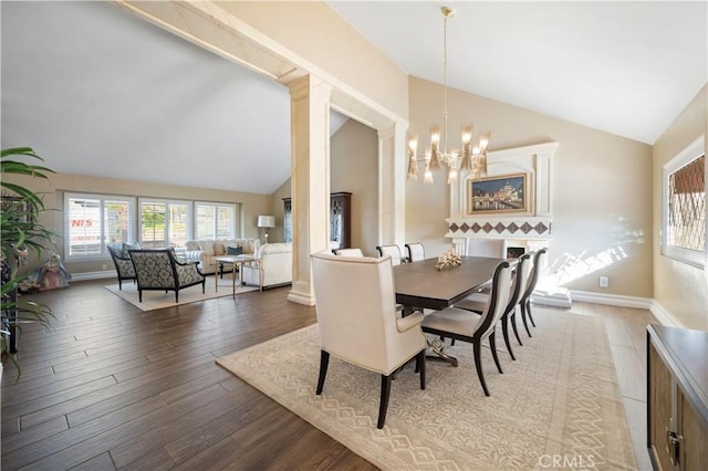 dining area featuring lofted ceiling, an inviting chandelier, and hardwood / wood-style flooring