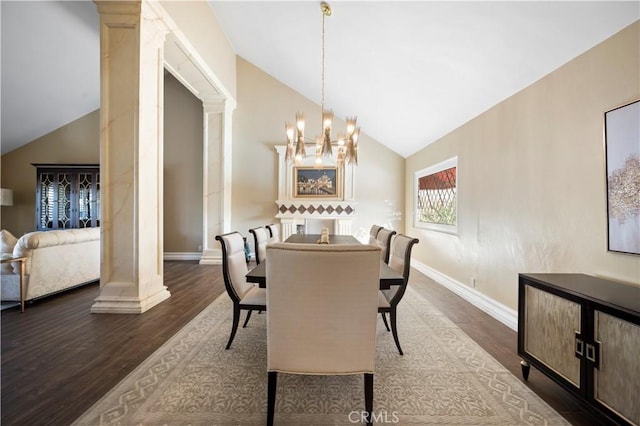 dining space featuring vaulted ceiling, a notable chandelier, dark hardwood / wood-style floors, and decorative columns