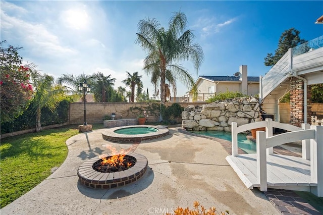 view of pool featuring an in ground hot tub, a fire pit, and a patio