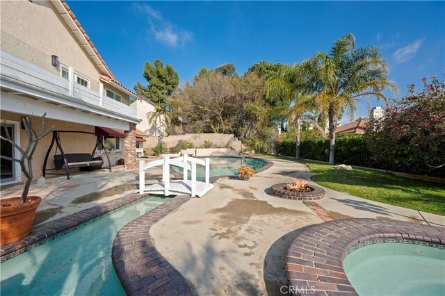 view of swimming pool with an outdoor fire pit and a patio area