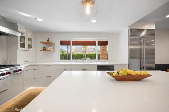 kitchen with white cabinets, sink, extractor fan, and stainless steel appliances