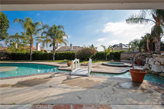 view of swimming pool featuring an in ground hot tub and a patio