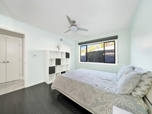 bedroom with ceiling fan, a closet, and dark hardwood / wood-style flooring