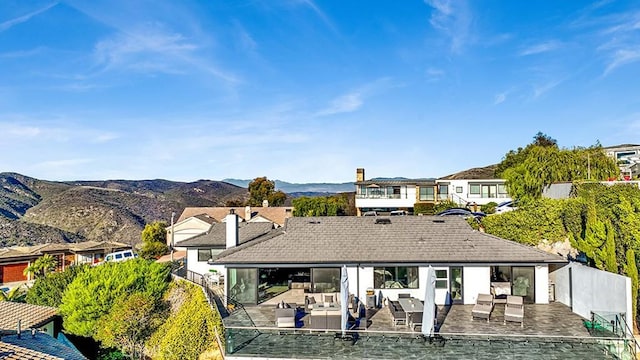 rear view of property with an outdoor living space, a mountain view, and a patio