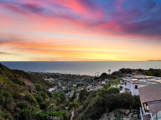 aerial view at dusk featuring a water view