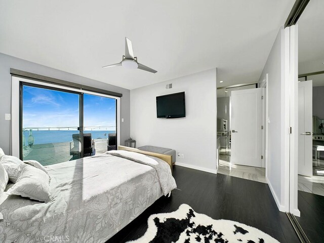 bedroom featuring ceiling fan, ensuite bath, dark hardwood / wood-style floors, and access to outside