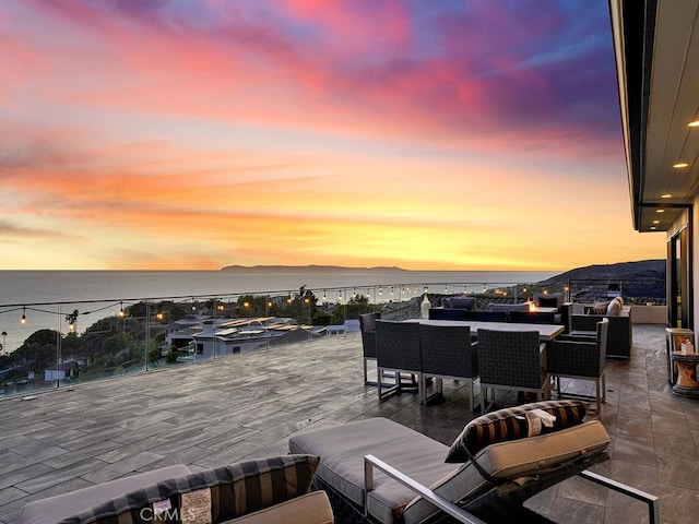 deck at dusk with a water and mountain view