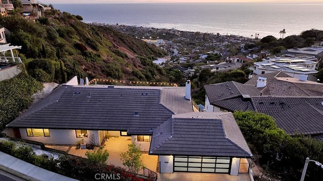 aerial view at dusk featuring a water view