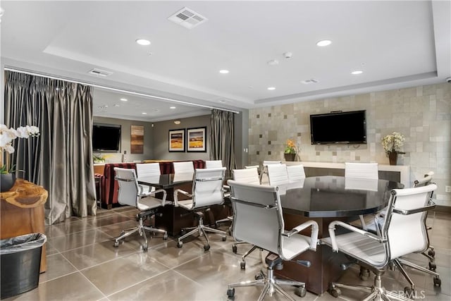 dining space featuring tile walls, a tray ceiling, and light tile patterned flooring