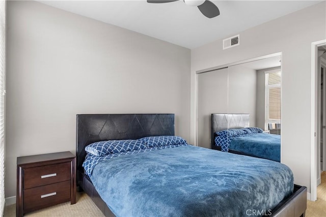 bedroom featuring light carpet, ceiling fan, and a closet