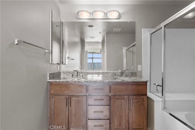 bathroom with bath / shower combo with glass door and vanity