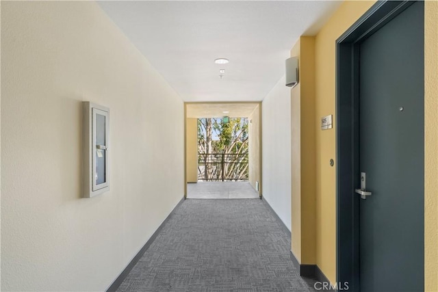 corridor featuring a wall of windows and dark carpet