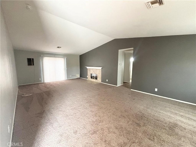 unfurnished living room featuring vaulted ceiling, carpet, and a fireplace