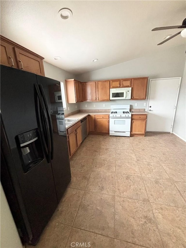 kitchen with ceiling fan, white appliances, light tile patterned flooring, and vaulted ceiling