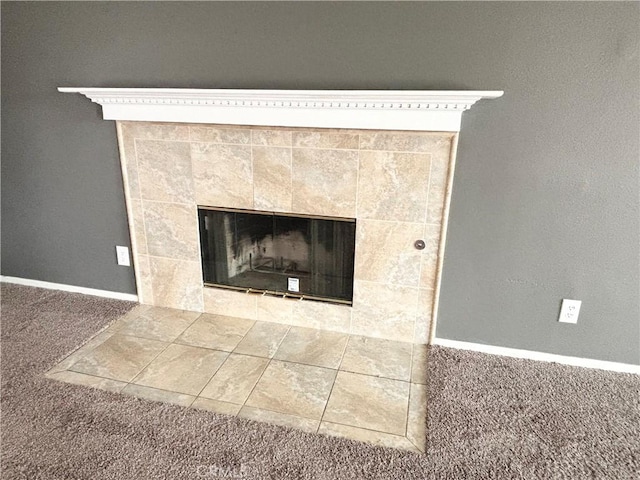 details with a tile fireplace and carpet