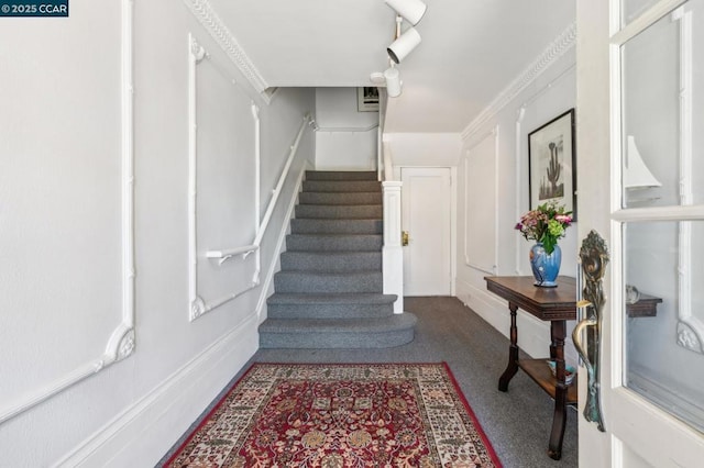 stairs with ornamental molding and carpet