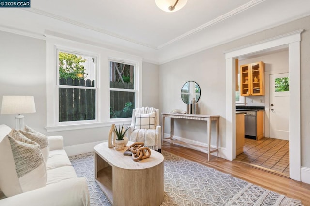 sitting room featuring wood-type flooring and ornamental molding