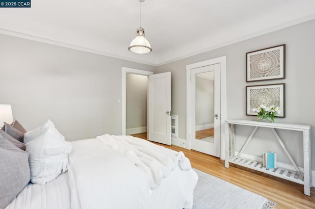 bedroom with hardwood / wood-style floors and crown molding