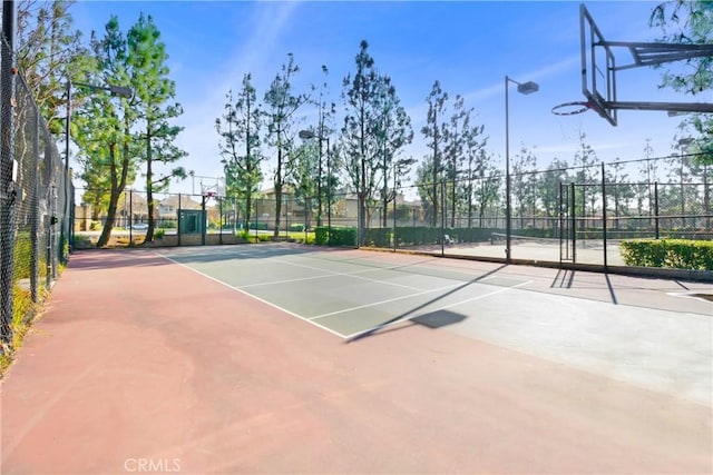 view of tennis court with basketball hoop