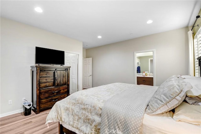 bedroom with light wood-type flooring and ensuite bathroom