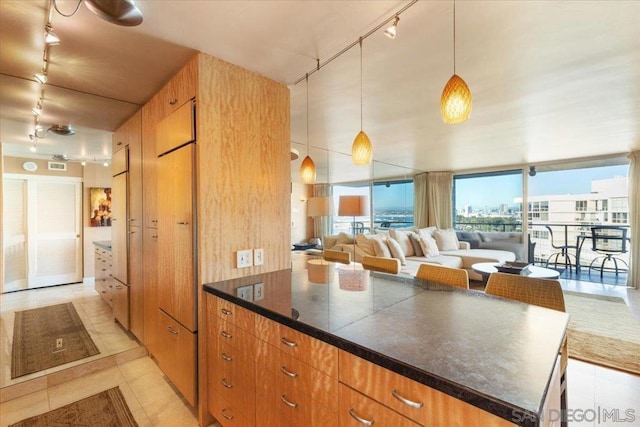 kitchen with light tile patterned floors, track lighting, hanging light fixtures, and a kitchen island