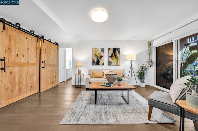 living room with a barn door and dark hardwood / wood-style floors