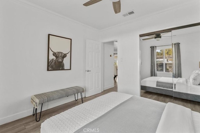 bedroom featuring ceiling fan, hardwood / wood-style floors, a closet, and crown molding