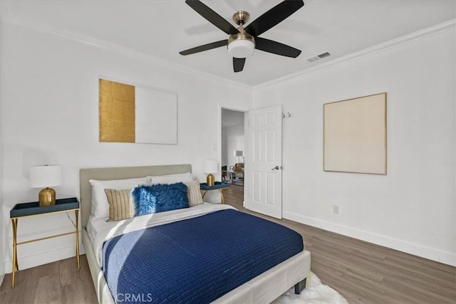 bedroom with ceiling fan, ornamental molding, and hardwood / wood-style floors