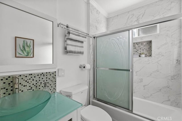 full bathroom with toilet, vanity, backsplash, crown molding, and enclosed tub / shower combo