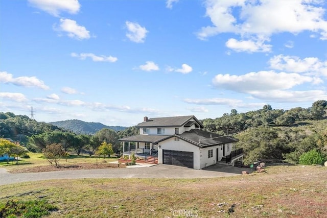 view of front of property featuring a garage, a mountain view, and a front yard