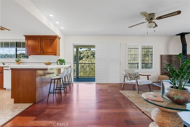 kitchen featuring dark hardwood / wood-style flooring, a breakfast bar, and ceiling fan