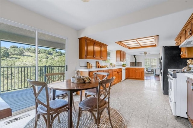 kitchen featuring white appliances, kitchen peninsula, and ceiling fan