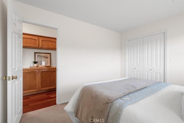 bedroom featuring light colored carpet and a closet