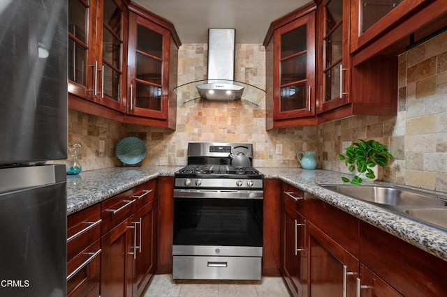 kitchen featuring light stone countertops, backsplash, wall chimney exhaust hood, and stainless steel appliances