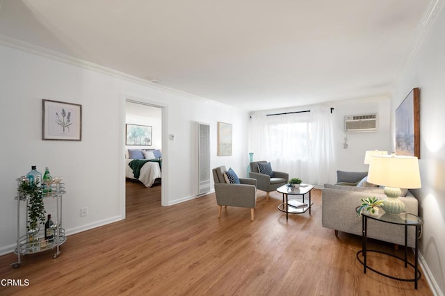 sitting room featuring crown molding, wood-type flooring, and an AC wall unit