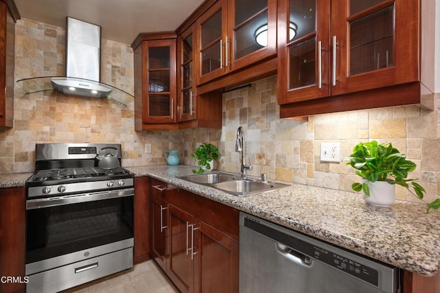 kitchen with stainless steel appliances, decorative backsplash, wall chimney range hood, light stone countertops, and sink