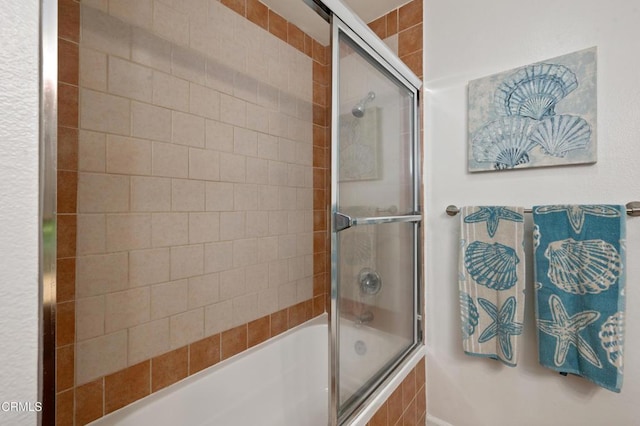 bathroom featuring combined bath / shower with glass door